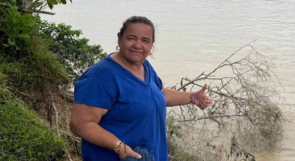 Jani Silva lächelt in die Kamera, hinter ihr ein Fluss