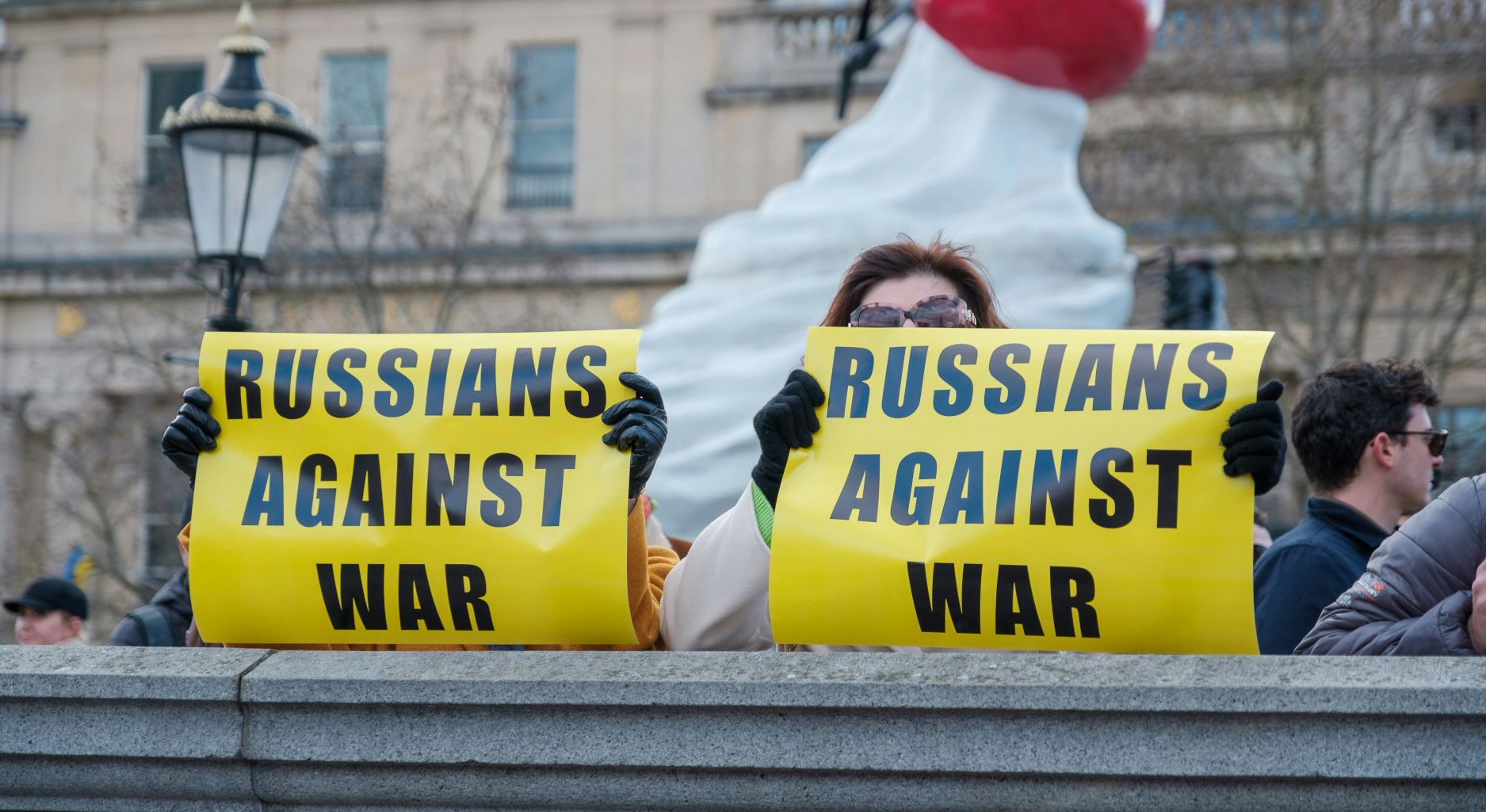 People holding signs saying "Russians Against War"
