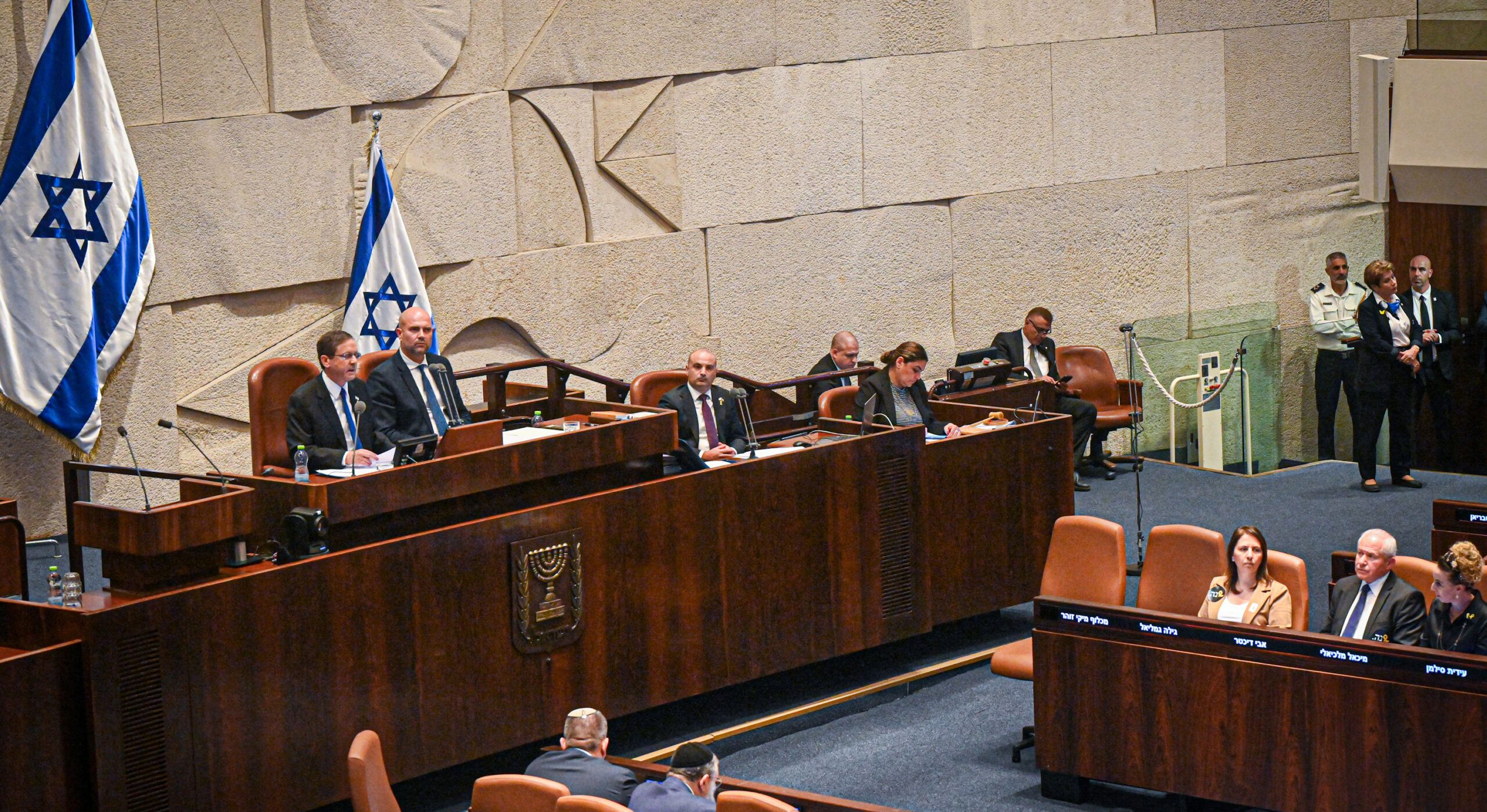 The picture shows the podium of the Knesset, where members of parliament open the parliamentary session. Other members of parliament sit in front of it and listen.