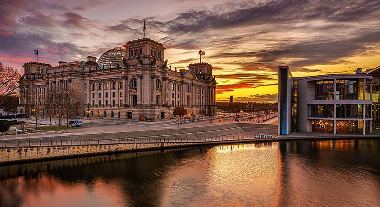 Building at river by sunset