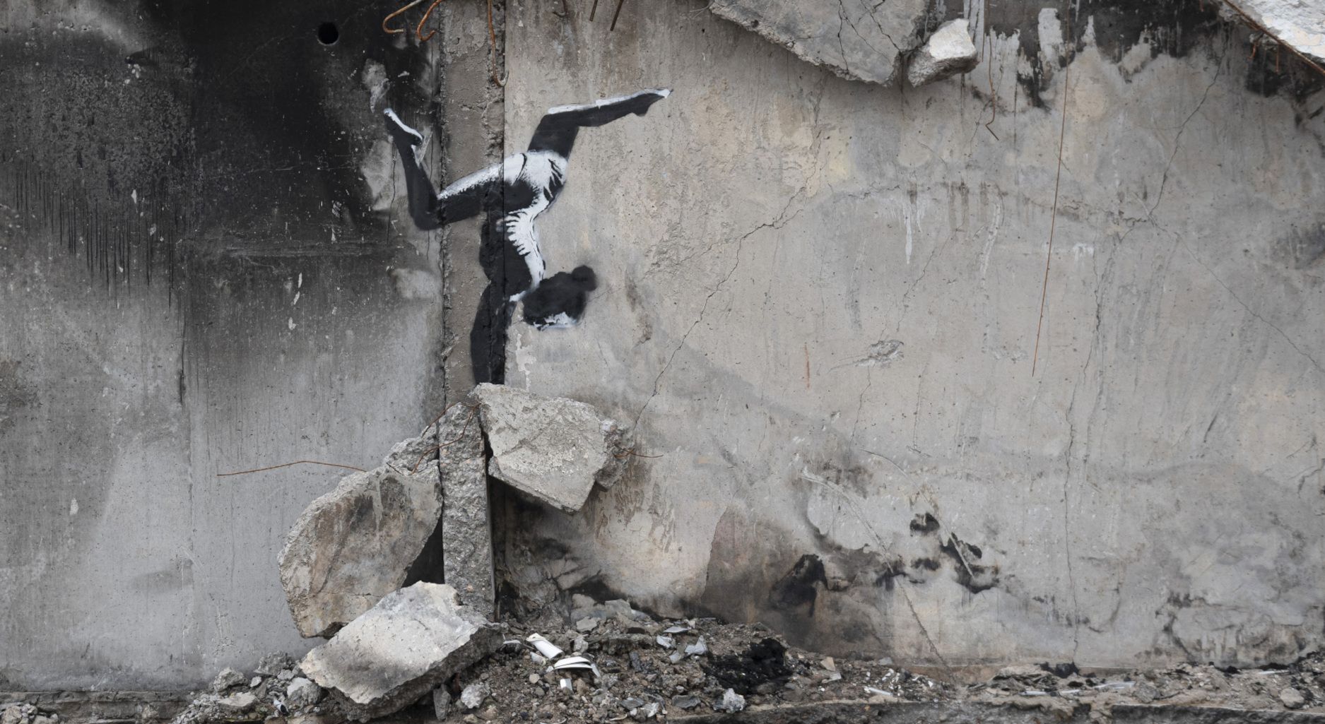A painting by British street artist Banksy is seen on a building destroyed by fighting in Borodyanka, Kyiv region, Ukraine. The painting shows a woman doing a handstand, apparently on the wreckage.