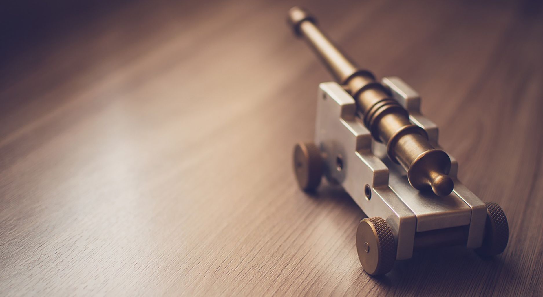 A toy canon sits on a wooden table