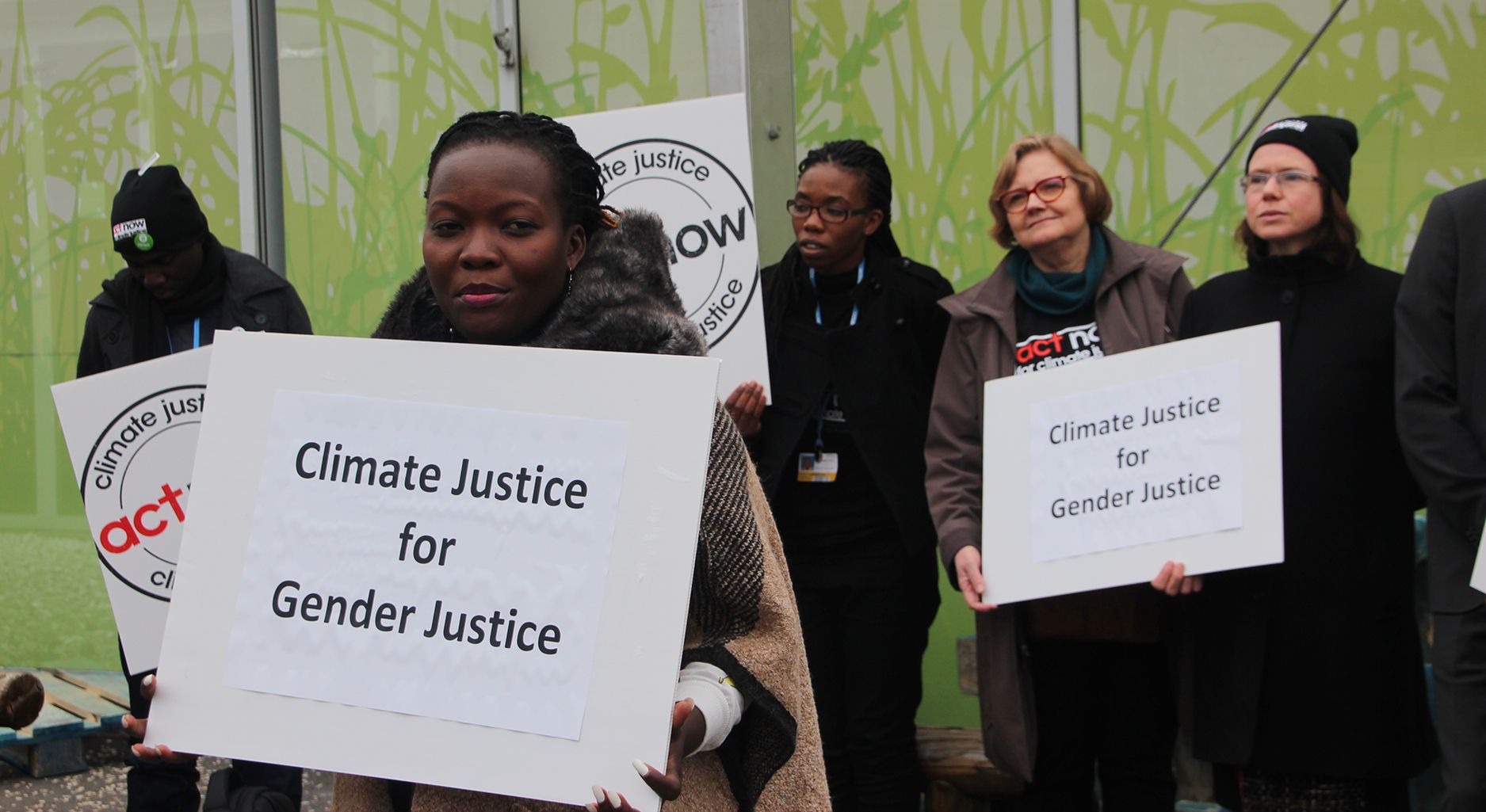 protester holding sign "Climate Justice for Gender Justice