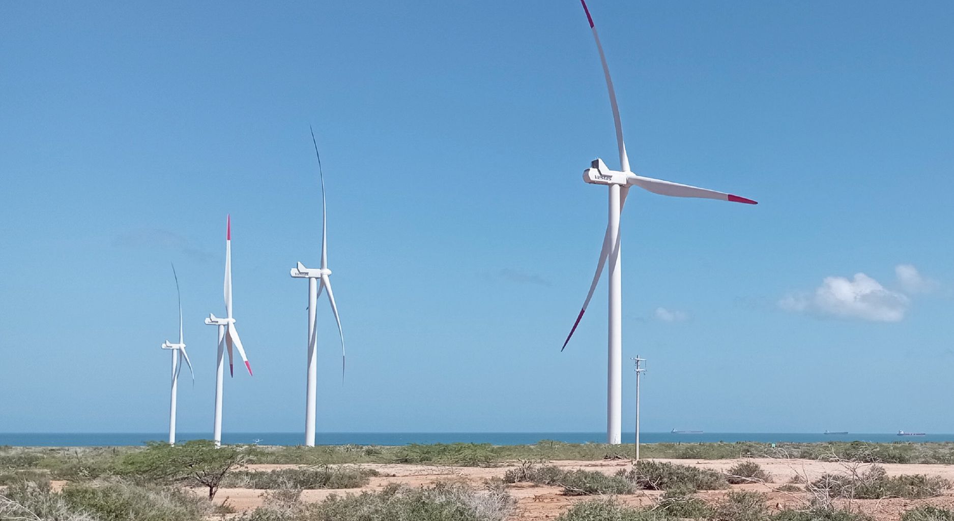 Photograph of a landscape with four wind turbines.
