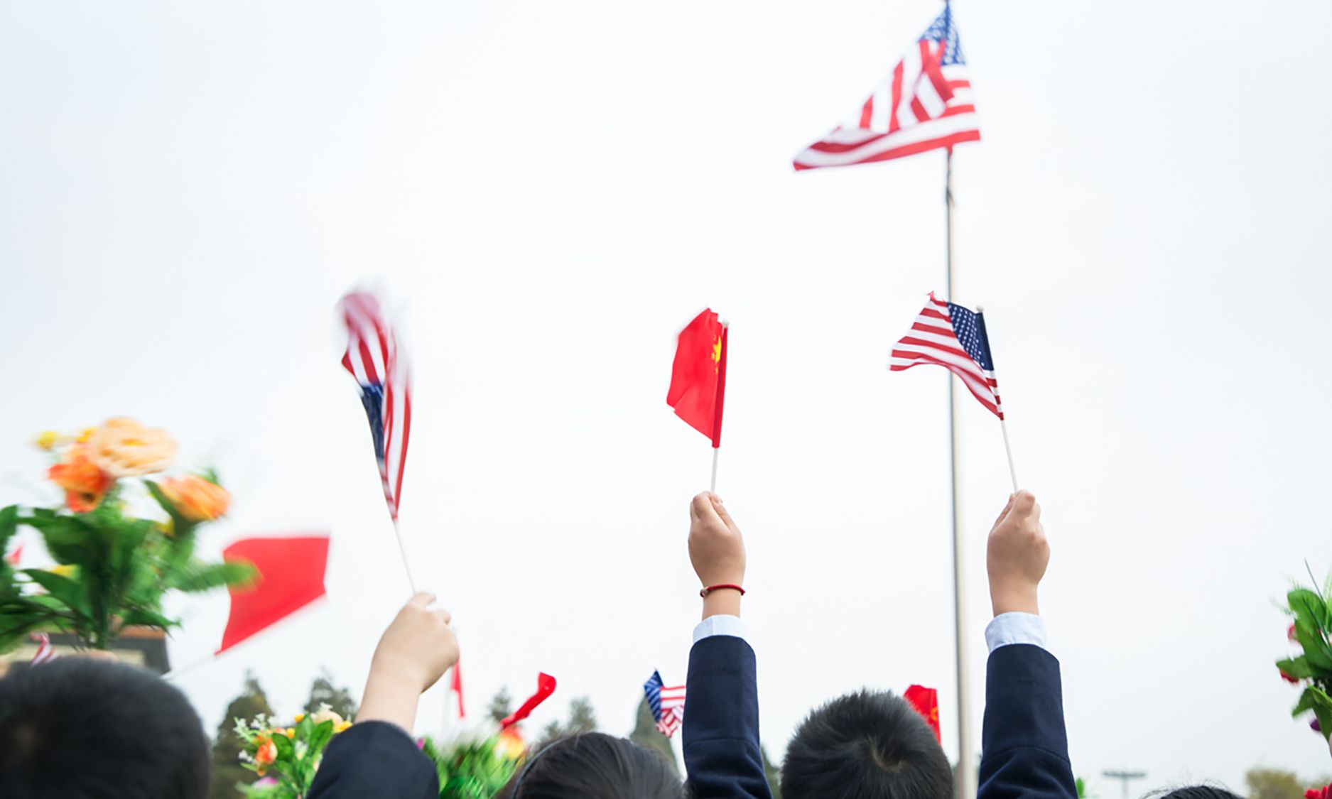 Kinder schwenken amerikanische und chinesische Flaggen