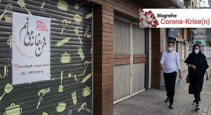 Foto eines geschlossenen Ladens im Iran. Auf einem Schild an der Tür steht: "Ich bleibe zuhause".