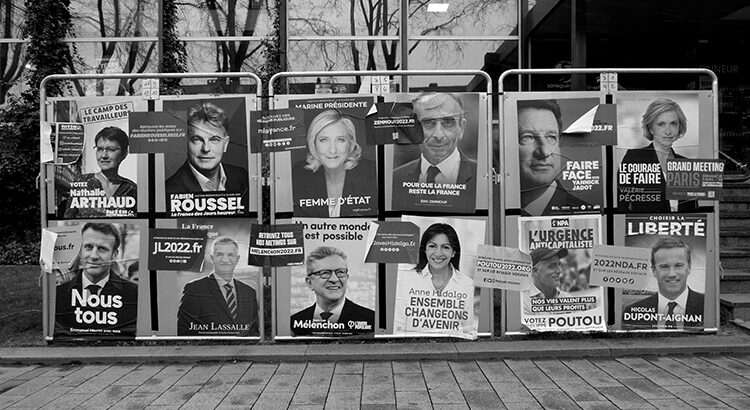 Image shows posters in the 2022 French presidential election. Title: "The Poetry of Empty Promises" by Caratello via flickr.