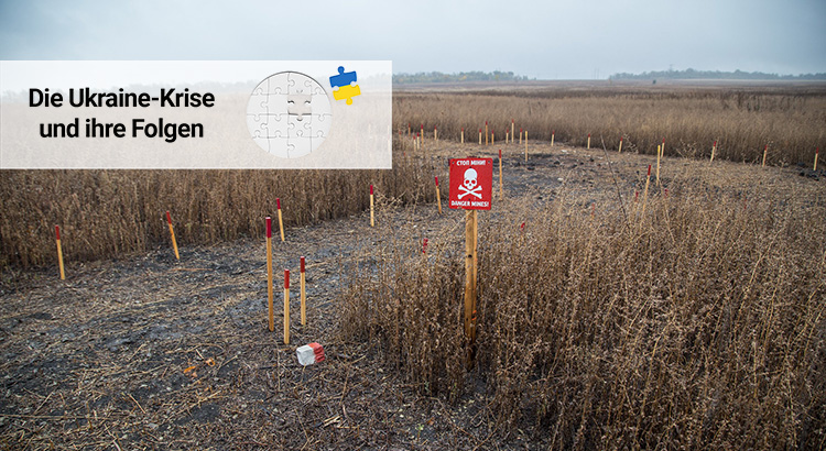 Image shows landscape in Ukraine with a sign saying "Danger mines!"