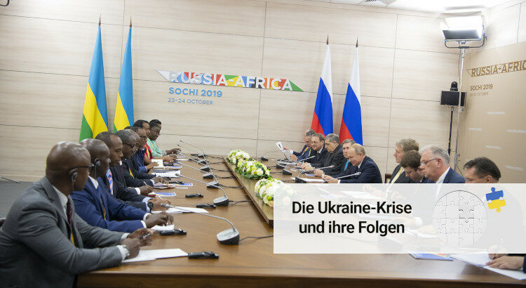 Wladimir Putin und die russische Delegation sitzen an einem Konferenztisch gegenüber von Paul Kagame und der ruandischen Delegation.