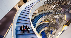 Treppen im Europäischen Parlament und zwei Personen, die sich in unterschiedliche Richtungen bewegen
