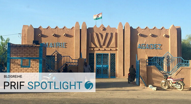 City hall of Agadez: On the building there are signs reading “Mairie Agadez” as well as a flag of Niger. Motorcycles are parked outside.