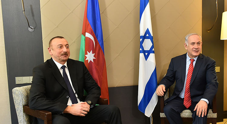 President Ilham Aliyev sitting with Prime Minister Benyamin Netanjahu with flags of Azerbaijan and Israel.