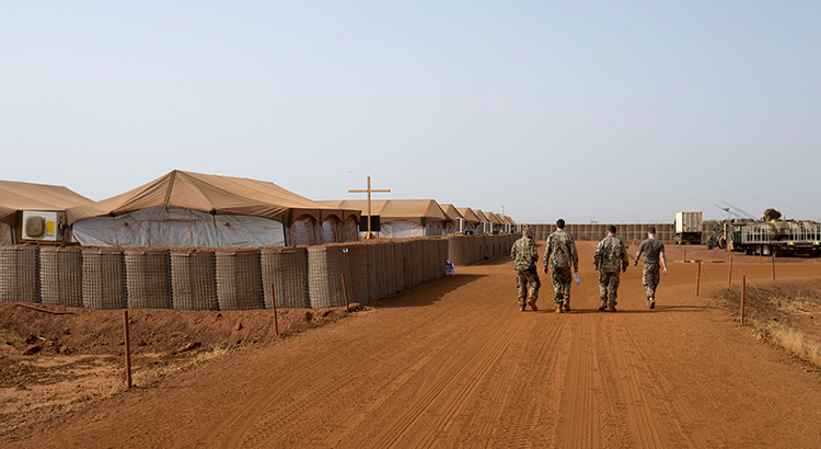 Vier Soldaten gehen durch das Camp Castor in Gao, Mali.