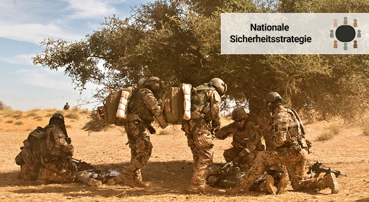 Eine Gruppe von Bundeswehrsoldaten sucht Schatten unter einem Baum