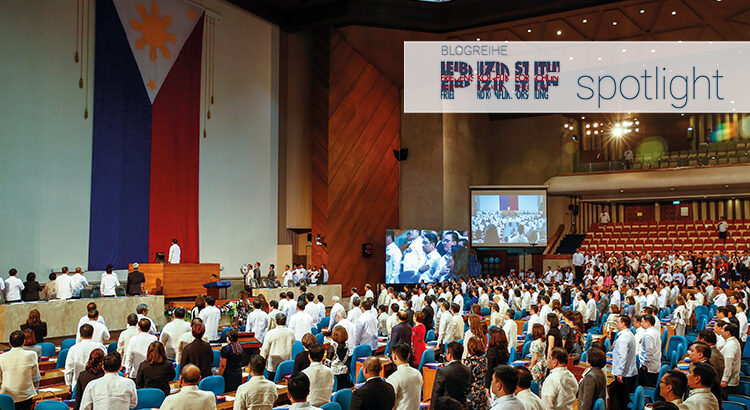 People standing in a large room with the Philippine flag hanging on the wall