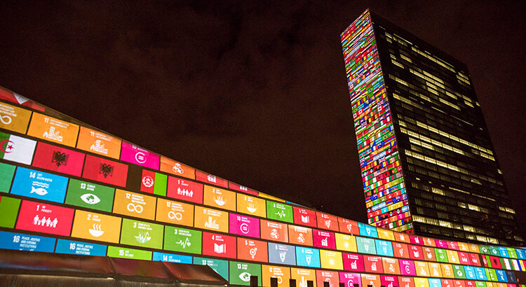 UN-Gebäude beleuchtet mit der Darstellung der 17 Sustainable Development Goals