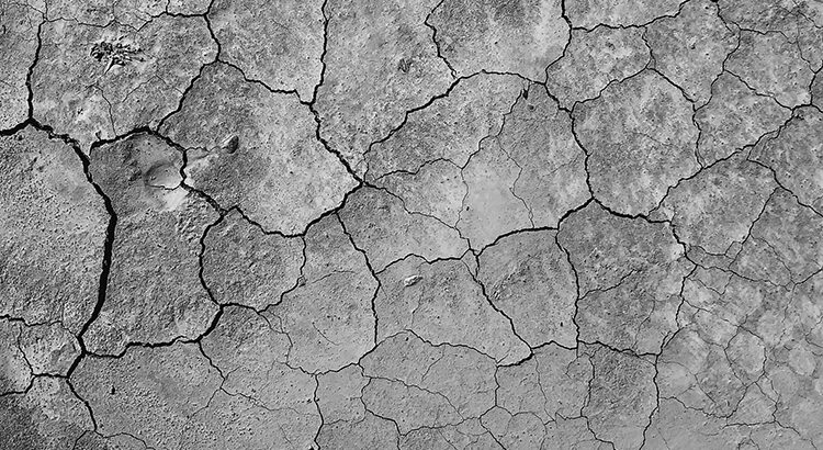 Schwarz-weiß-Foto von Rissen in Boden