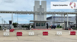 Building with writing "Thilawa Special Economic Zone" that has closed gates and barriers in the driveway