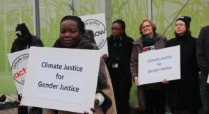 protester holding sign "Climate Justice for Gender Justice