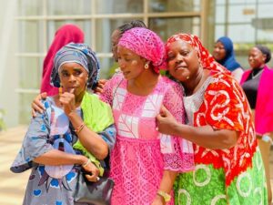Three women with colorful traditional dresses and headpieces