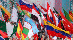 Flags of the BRICS countries are waved in a rain of confetti.