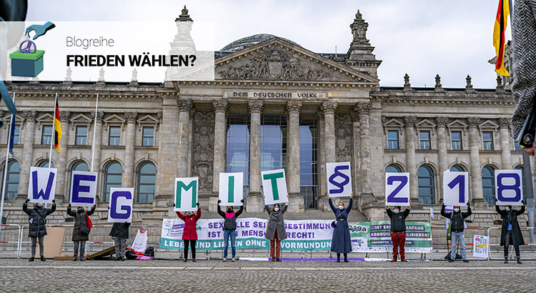 Protestierende vor dem Reichstagsgebäude in Berlin halten Schilder hoch, aus denen sich zusammengesetzt der Text ergibt "Weg mit §218"