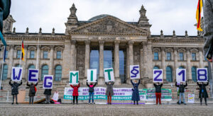 Protestierende vor dem Reichstagsgebäude in Berlin halten Schilder hoch, aus denen sich zusammengesetzt der Text ergibt "Weg mit §218"