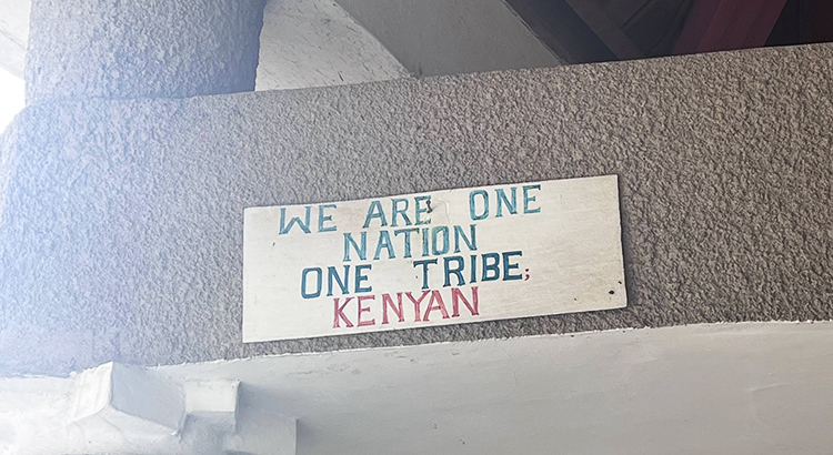 Plaque on a wall reading: We Are one Nation One Tribe Kenyan.