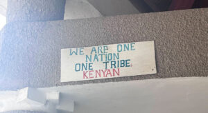 Plaque on a wall reading: We Are one Nation One Tribe Kenyan.