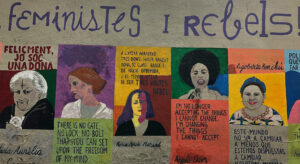 A colourful mural with five pictures of famous women like Angela Davis, Virginia Woolf or Rigoberta Menchi and quotes. Above, the headline reads Feministes I Rebels.