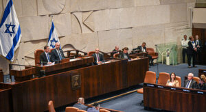 The picture shows the podium of the Knesset, where members of parliament open the parliamentary session. Other members of parliament sit in front of it and listen.