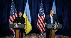 Donald Trump und Wolodymyr Selenskiy stehen an Rednerpulten, im Hintergrund die ukrainische und die US-amerikanische Flagge.