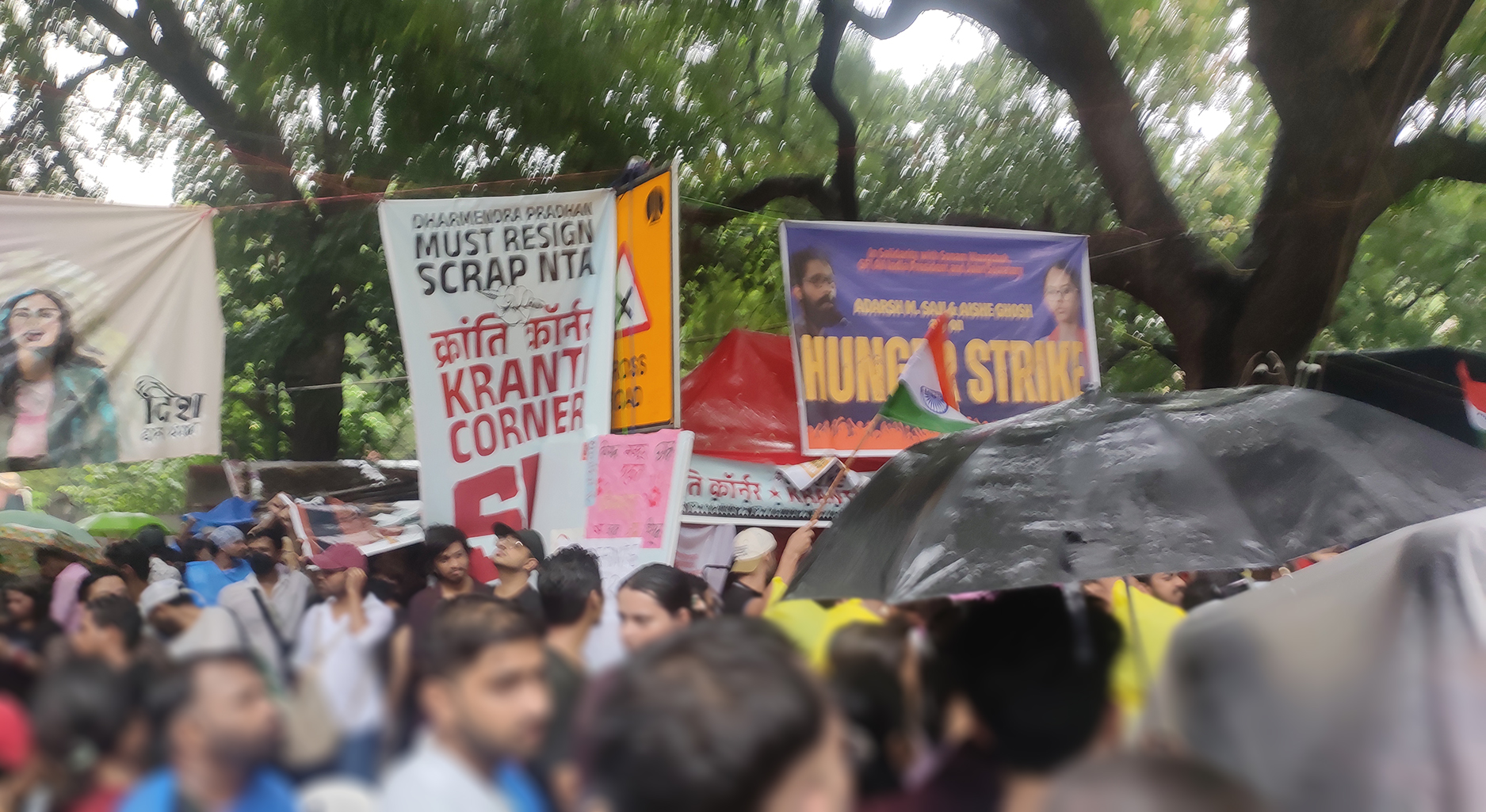 Group of protesters holding signs showing various people and text. On one of them the words "hunger strike" can be read, another one says "Dharmendra Pradham must resign. Scrap NTA"