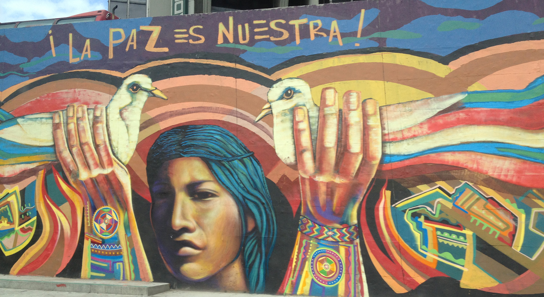Peace Graffiti on a wall in Bogota: Woman holding tow peace doves, the graffiti says ‘La Paz es Nuestra!’